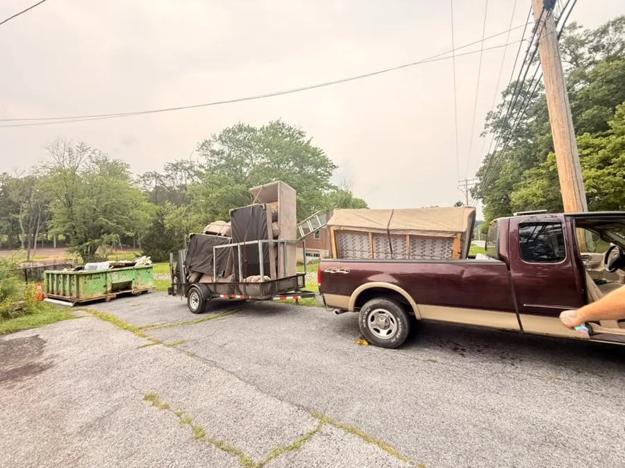 DumpGo truck and trailer loaded with couches and furniture